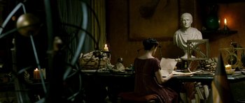 Movie still from “Agora” (2009), directed by Alejandro Amenábar – A woman sitting at a table writing on a paper; Wide shot, High angle