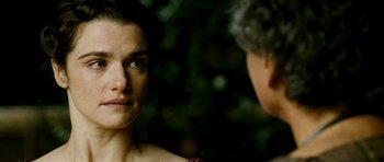 Movie still from “Agora” (2009), directed by Alejandro Amenábar – A woman standing next to another woman in front of a tree; Close Up shot, Over the shoulder angle