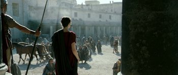 Movie still from “Agora” (2009), directed by Alejandro Amenábar – A man in a red robe is standing in front of a group of people; Extreme Wide shot, Over the shoulder angle