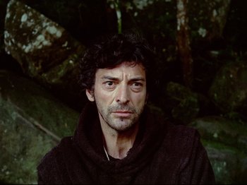 Movie still from “Aguirre, the Wrath of God” (1972), directed by Werner Herzog – A person wearing a robe; Close Up shot, Over the shoulder angle