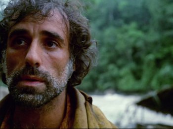 Movie still from “Aguirre, the Wrath of God” (1972), directed by Werner Herzog – A person with a beard near a body of water; Close Up shot, Low angle