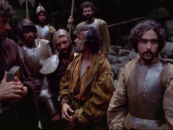 Movie still from “Aguirre, the Wrath of God” (1972), directed by Werner Herzog – A group of men dressed in medieval armor; Medium shot, High angle
