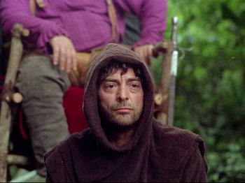 Movie still from “Aguirre, the Wrath of God” (1972), directed by Werner Herzog – A man wearing a brown robe and a purple shirt; Close Up shot, Low angle