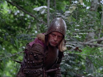 Movie still from “Aguirre, the Wrath of God” (1972), directed by Werner Herzog – A man dressed as a medieval knight in the woods; Medium shot, Low angle