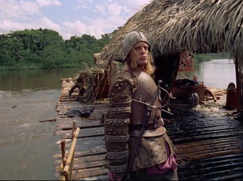 Movie still from “Aguirre, the Wrath of God” (1972), directed by Werner Herzog – A man dressed as a roman soldier standing on a pier; Wide shot, Low angle