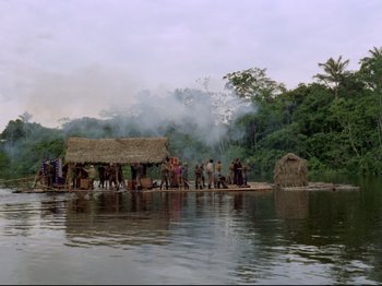 Movie still from “Aguirre, the Wrath of God” (1972), directed by Werner Herzog – A group of people standing on top of a body of water; Extreme Wide shot, High angle