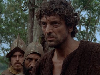 Movie still from “Aguirre, the Wrath of God” (1972), directed by Werner Herzog – A group of men standing next to each other in the woods; Close Up shot, Low angle