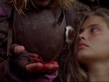 Movie still from “Aguirre, the Wrath of God” (1972), directed by Werner Herzog – A young girl holding a piece of meat in her hand; Close Up shot, Over the shoulder angle