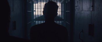 Movie still from “Ain't Them Bodies Saints” (2013), directed by David Lowery – A man standing in front of a jail cell; Medium shot, Low angle