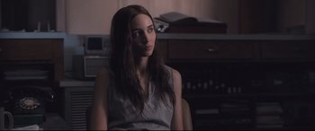 Movie still from “Ain't Them Bodies Saints” (2013), directed by David Lowery – A beautiful young lady sitting in front of a computer monitor; Medium shot, Over the shoulder angle