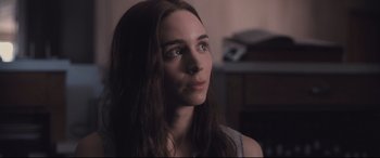 Movie still from “Ain't Them Bodies Saints” (2013), directed by David Lowery – A person with long brown hair; Close Up shot, Over the shoulder angle