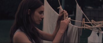 Movie still from “Ain't Them Bodies Saints” (2013), directed by David Lowery – A woman hanging clothes on a clothesline; Close Up shot, Low angle