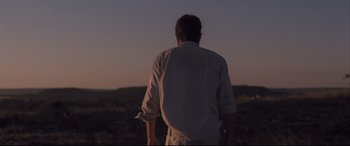 Movie still from “Ain't Them Bodies Saints” (2013), directed by David Lowery – A man standing in the middle of a field at night; Medium shot, Low angle