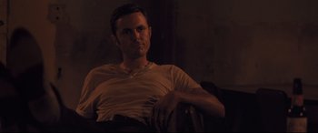Movie still from “Ain't Them Bodies Saints” (2013), directed by David Lowery – A man sitting in a chair in the dark; Medium shot, Low angle