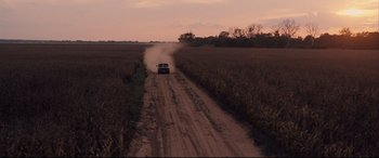 Movie still from “Ain't Them Bodies Saints” (2013), directed by David Lowery – A car driving down a dirt road near a field; Extreme Wide shot, High angle