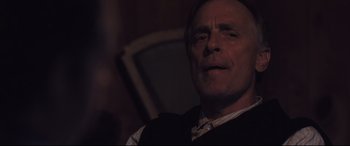 Movie still from “Ain't Them Bodies Saints” (2013), directed by David Lowery – A person wearing a suit and tie; Close Up shot, Over the shoulder angle