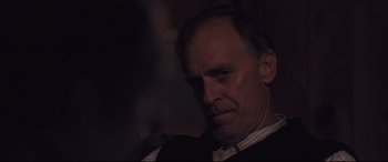 Movie still from “Ain't Them Bodies Saints” (2013), directed by David Lowery – A person wearing a suit and tie; Close Up shot, Over the shoulder angle