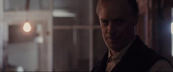 Movie still from “Ain't Them Bodies Saints” (2013), directed by David Lowery – An older man in a black jacket is looking at the camera; Close Up shot, Over the shoulder angle