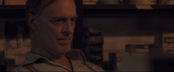 Movie still from “Ain't Them Bodies Saints” (2013), directed by David Lowery – A person sitting in a room; Close Up shot, Over the shoulder angle