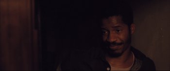 Movie still from “Ain't Them Bodies Saints” (2013), directed by David Lowery – A person in a dark room; Close Up shot, Over the shoulder angle