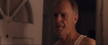 Movie still from “Ain't Them Bodies Saints” (2013), directed by David Lowery – An older man is looking at the camera; Close Up shot, Over the shoulder angle