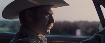 Movie still from “Ain't Them Bodies Saints” (2013), directed by David Lowery – A person wearing a cowboy hat; Close Up shot, Over the shoulder angle
