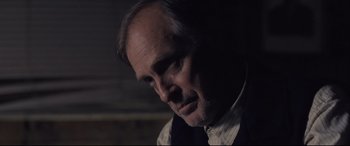Movie still from “Ain't Them Bodies Saints” (2013), directed by David Lowery – A person wearing a suit and tie; Close Up shot, Over the shoulder angle