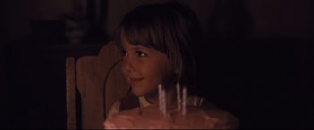 Movie still from “Ain't Them Bodies Saints” (2013), directed by David Lowery – A young girl sitting in front of a birthday cake; Close Up shot, Over the shoulder angle