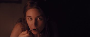 Movie still from “Ain't Them Bodies Saints” (2013), directed by David Lowery – A woman holding a spoon in her mouth in a dark room; Close Up shot, High angle