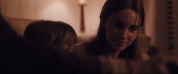 Movie still from “Ain't Them Bodies Saints” (2013), directed by David Lowery – A woman and a child in a dark room; Close Up shot, Over the shoulder angle