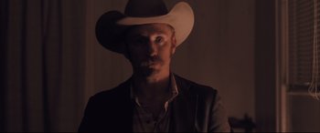 Movie still from “Ain't Them Bodies Saints” (2013), directed by David Lowery – A man wearing a cowboy hat in the dark; Close Up shot, Low angle