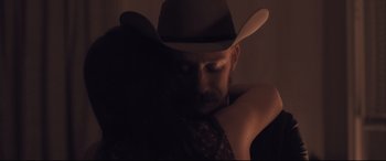 Movie still from “Ain't Them Bodies Saints” (2013), directed by David Lowery – A man in a cowboy hat is leaning against a wall; Close Up shot, Over the shoulder angle