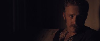 Movie still from “Ain't Them Bodies Saints” (2013), directed by David Lowery – A person sitting on a couch; Close Up shot, Over the shoulder angle