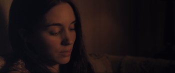 Movie still from “Ain't Them Bodies Saints” (2013), directed by David Lowery – A person sitting on a couch with her eyes closed; Close Up shot, High angle