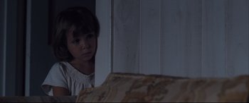 Movie still from “Ain't Them Bodies Saints” (2013), directed by David Lowery – A young girl standing in front of a couch looking at the camera; Close Up shot, High angle