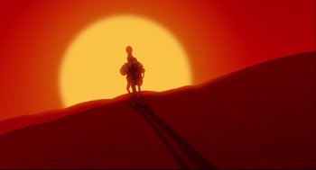 Movie still from “Aladdin” (1992), directed by John Musker – A man riding a camel through the desert at sunset; Extreme Wide shot, Low angle
