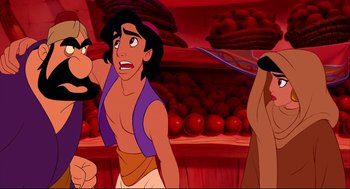 Movie still from “Aladdin” (1992), directed by John Musker – A man in a purple shirt is in the middle of an animated scene; Medium shot, Over the shoulder angle