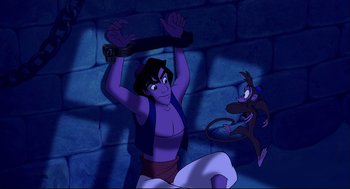 Movie still from “Aladdin” (1992), directed by John Musker – A man holding onto a piece of wood while another man holds on to a monkey; Wide shot, Overhead angle