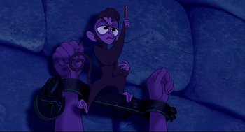 Movie still from “Aladdin” (1992), directed by John Musker – A monkey sitting on top of a person's hands; Medium shot, Overhead angle
