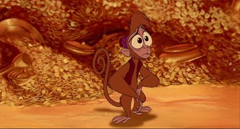 Movie still from “Aladdin” (1992), directed by John Musker – A cartoon monkey standing in front of a pile of gold; Medium shot, High angle