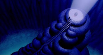 Movie still from “Aladdin” (1992), directed by John Musker – An image of a person climbing a ladder to the top of a mountain; Extreme Wide shot, Overhead angle