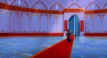 Movie still from “Aladdin” (1992), directed by John Musker – A man in a black robe is standing in front of a red carpet; Extreme Wide shot, High angle