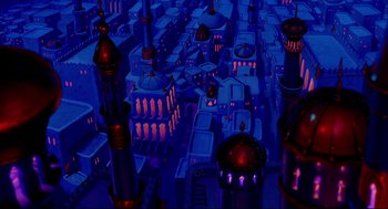 Movie still from “Aladdin” (1992), directed by John Musker – An aerial view of a city at night with many buildings; Extreme Wide shot, Overhead angle