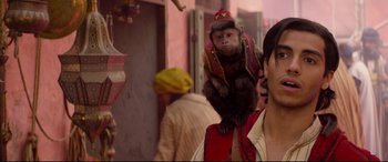 Movie still from “Aladdin” (2019), directed by Guy Ritchie – A monkey sitting on top of a man's shoulder; Close Up shot, Over the shoulder angle