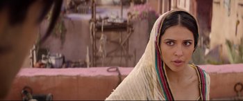 Movie still from “Aladdin” (2019), directed by Guy Ritchie – A woman in a white dress with a pink and green shawl; Close Up shot, Over the shoulder angle