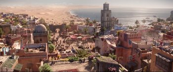 Movie still from “Aladdin” (2019), directed by Guy Ritchie – An aerial view of a city with a beach in the background; Extreme Wide shot, High angle