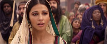 Movie still from “Aladdin” (2019), directed by Guy Ritchie – A woman in a green and white dress with a beard; Close Up shot, Over the shoulder angle