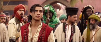 Movie still from “Aladdin” (2019), directed by Guy Ritchie – A group of men standing next to each other; Medium shot, Over the shoulder angle