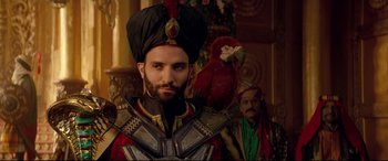 Movie still from “Aladdin” (2019), directed by Guy Ritchie – A man with a red parrot on his shoulder; Close Up shot, Over the shoulder angle