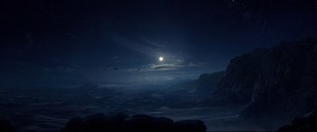 Movie still from “Aladdin” (2019), directed by Guy Ritchie – A full moon setting in the night sky over the ocean; Extreme Wide shot, High angle
